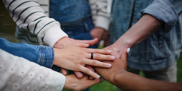 An image of 5 hands on top of each other.