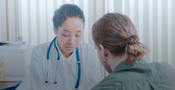 A medical professional talking to a male patient.